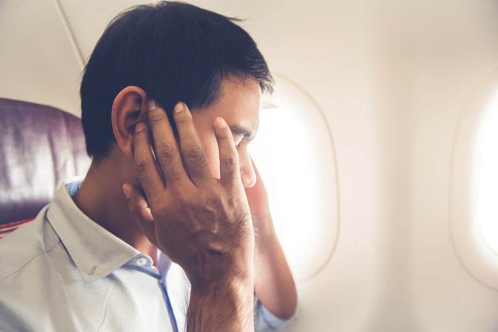 male passenger having ear problems during a flight